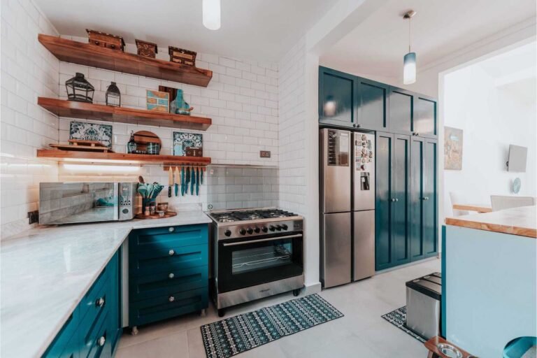Modern kitchen with teal cabinets, open shelving, and intentional design for functionality and style