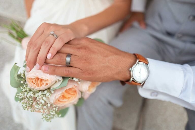 Couple holding hands with wedding rings during a prayer against marriage destroyers.