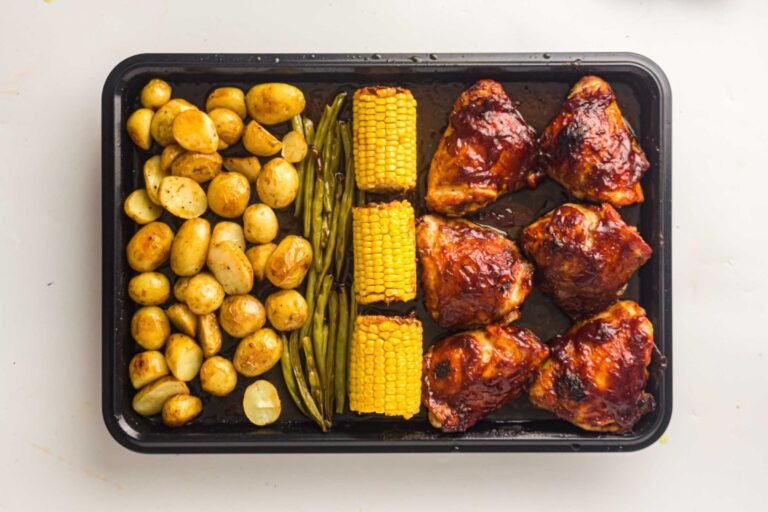 Sheet Pan BBQ Chicken Thighs with baby potatoes, green beans and corn cooked on one pan.